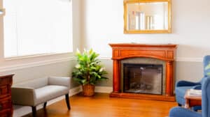 Waiting room at Edgefield Post Acute with seating and a fireplace