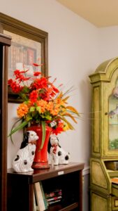 Flowers in a vase in front of some wall decor